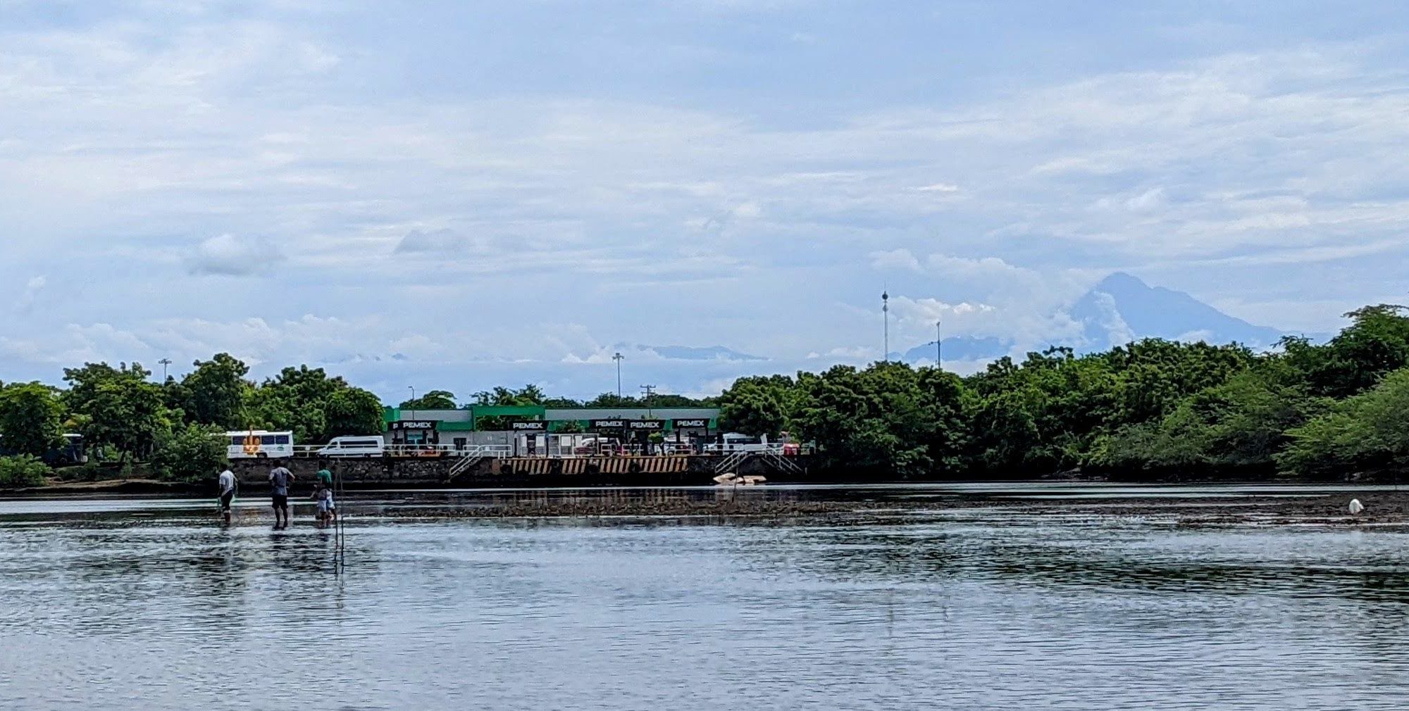Several men casting nets for fish at low tide within Chiapas harbor